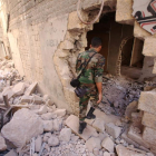 Un soldado del Ejército sirio inspecciona un edificio dañado en Alepo.-AFP / YOUSSEF KARWASHAN