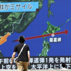 Un viandante observa la trayectoria del misil norcoreano en una pantalla gigante colocada en Tokio (Japón).-EFE / KIMIMASA MAYAMA