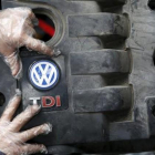 Un trabajador muestra el logo de un motor diésel TDI de Volkswagen de segunda mano en Jelah, Bosnia.-REUTERS/DADO RUVIK