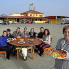Mari Carmen Amez, en primer término, con un chuletón de búfalo, y su familia detrás. De i. a d.: Miriam, Carlos, Eduardo, Camino, Laura, Juan y Ana-Argicomunicación