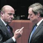 El ministro de Economía español, Luis de Guindos, y el presidente del BCE, Mario Draghi, durante una reunión del Eurogrupo.-EFE / JULIEN WARNAND
