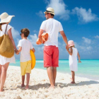 Una familia disfruta de unas vacaciones en una playa paradisiaca.-SHUTTERSTOCK