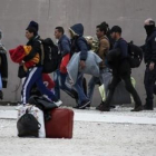 La policía griega escolta a inmigrantes en el exterior de un estadio en el sur de Atenas.-AP / YORGOS KARAHALIS.