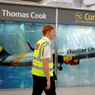 Un operario camina frente al puesto de información de la operadora de viajes Thomas Cook.-EFE