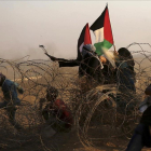 Manifestantes palestinos lanzan piedras contra los soldados israelís en las protestas de este viernes en Khan Younis, en el sur de la frontera de Gaza.-AP / ADEL HANA