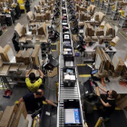 Trabajadores en una planta empaquetadora de pedidos de Amazon.-REUTERS