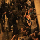 Los antidisturbios de los Mossos contienen a manifestantes en la Vía Laietana de Barcelona, junto a la comisaría de la Policía Nacional.-FERRAN NADEU