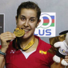 Carolina Marín 'muerde' la medalla de oro que la acredita como ganadora del Abierto de Malasia de bádminton.-Foto: AP / JOSHUA PAUL