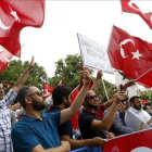Ciudadanos turcos ondean banderas de su país durante una protesta en la víspera del primer aniversario del fallido golpe de Estado.-ERDEM SAHIN
