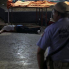 Un policía frente a un hombre asesinado en Acapulco.-REUTERS