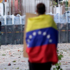 Un hombre con la bandera venezolana en la capital, Caracas.-UESLEI MARCELINO (REUTERS)