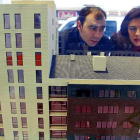 Una pareja mira la maqueta de un bloque de viviendas.-D. S.