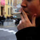 Un joven fumando un cigarro.-