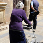 Una mujer se ayuda de un andador para caminar por la calle. / VALENTÍN GUISANDE-