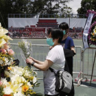 Dos mujeres colocan flores en el memorial a las víctimas de Tiananmen, en Hong Kong.-Foto:   Kin Cheung / AP / KIN CHEUNG