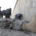 Militares inspeccionan el cadáver de un miliciano en la sede del Ministerio del Interior afgano, en Kabul.-/ RAHMAT GUL