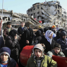 Decenas de sirios hacen cola para recibir comida en las afueras de Damasco.-AP