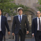 El president Carles Puigdemont, entre el vicepresidente Oriol Junqueras y el consejero Jordi Turull, en el Palau de la Generalitat.-ALBERT BERTRAN