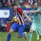 Iniesta pelea por el balón con Saúl, el jugador del Atlético, en el Calderón.-REUTERS / JUAN MEDINA