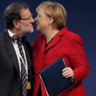 Rajoy y Merkel se saludan durante un congreso del Partido Popular Europeo.-EL PERIÓDICO