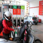 Una joven reposta carburante para su moto en una gasolinera, el martes.-RICARD CUGAT