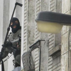 Un agente utiliza una cámera extendida para espiar en el interior de un piso, en Molenbeek, este lunes.-REUTERS / YVES HERMAN