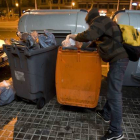 Un joven busca comida en un contenedor de basura orgánica, en Barcelona.-Foto: ALBERT BERTRAN