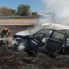 Los bomberos sofocan las llamas con el vehículo completamente calcinado. VICENTE-ICAL