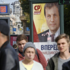 Peatones pasas por delante de un cartel electoral en San Petersburgo.-DMITRO LOVETSKY / AP
