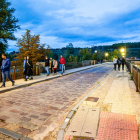 Varias personas transitan por el puente de piedra de Soria.