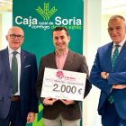 El responsable de Cáritas Soria con el cheque entregado por Caja Rural de Soria.