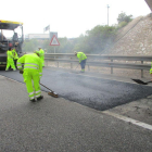 Varios operarios extienden asfalto en una carretera de  Soria.