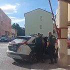 Agentes de la Guardia Civil meten al detenido en el coche oficial.