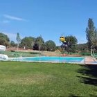 Un helicóptero carga agua en la piscina de Navaleno, previamente desalojada, para sofocar un incendio en la zona.