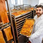 Pablo Romero posa entre pancetas frescas y torreznos recién prefritos en la fábrica.