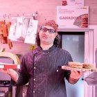 Carlos Hernández con el premio y las hamburguesas en su carnicería.