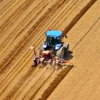 Un agricultor ara un campo de cultivo con su tractor para proceder a la sementera.