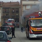 Los bomberos intervienen en la cochera incendiada, de la que sale bastante humo.