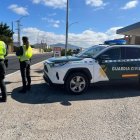 Dos agentes de la Guardia Civil junto a un vehículo del Cuerpo.