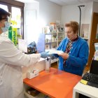 Usuaria recogiendo la medicación semanal en la farmacia rural de Valdeavellano, en Soria.