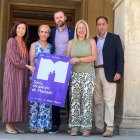 Las autoridades posan con el cartel de la nueva campaña de promoción comercial.