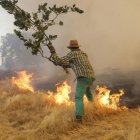 Un hombre apagando fuego.