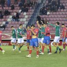 Los jugadores del Coruxo celebran la victoria y los del Numancia se lamentan de la derrota.
