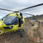 El helicóptero de rescate de la Junta de Castilla y León y, al fondo, atenciones sanitarias al herido.