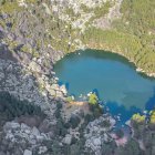 La Laguna Negra, desde el aire: un espejo glaciar oculto entre montañas, rocas y bosque espeso en el corazón del parque natural soriano