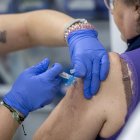 Archivo - Una mujer se vacuna durante la campaña de vacunación contra la gripe.