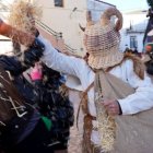 Un zarrón, con su cesta de mimbre y el saco lleno de paja, reparte manojos entre los vecinos en pleno Carnaval de Borobia, una de las tradiciones más singulares de Soria.