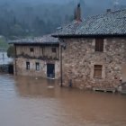 El río Duero desbordado en Salduero a punto de entrar en las casas.