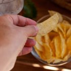 Una patata frita crujiente recién tomada del cuenco, el gesto más sencillo que confirma que cuando el producto es bueno, no necesita presentación.