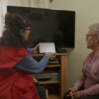 Voluntarios de Cruz Roja instalando uno de los asistentes virtuales para combatir la soledad de los mayores.